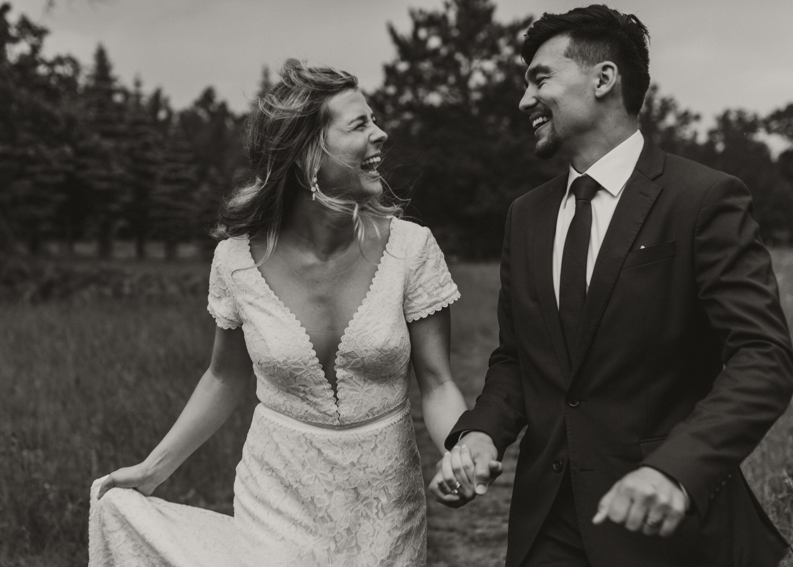 Bride and Groom run through the field at The Atrium in Solon Springs during sunset