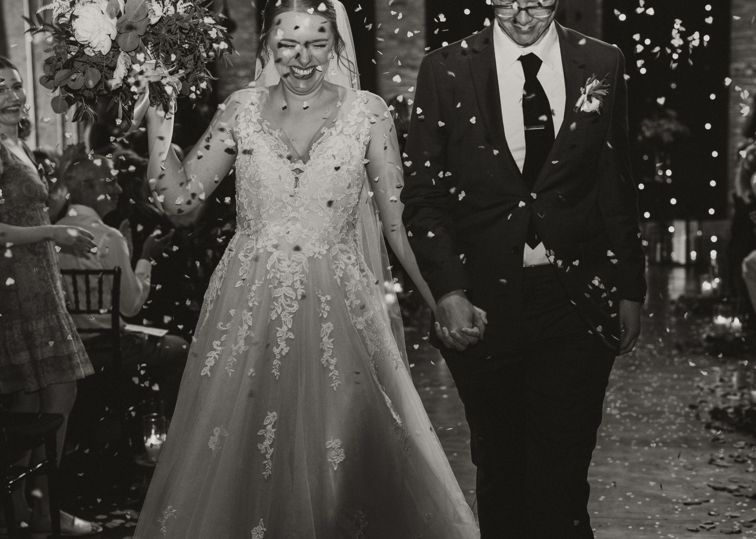 Bride and Groom exit their ceremony as guests throw confetti at Clyde Iron Works in Duluth, Minnesota