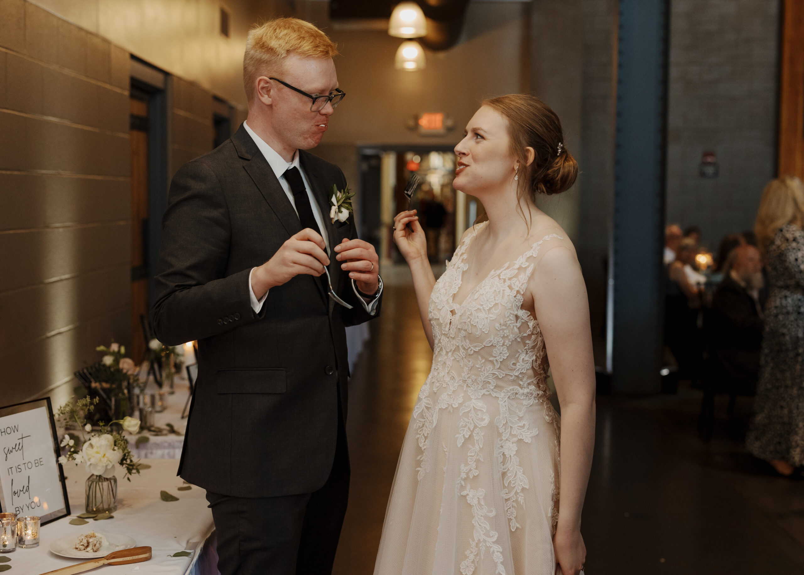 Bride and Groom eat their wedding cake on their June wedding day at Clyde Iron Works in Duluth, Minnesota