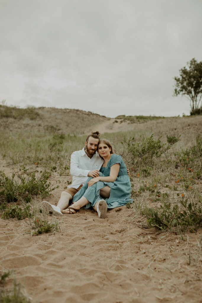 Couple embraces on Park Point Beach in Duluth Minnesota during their engagement photo session