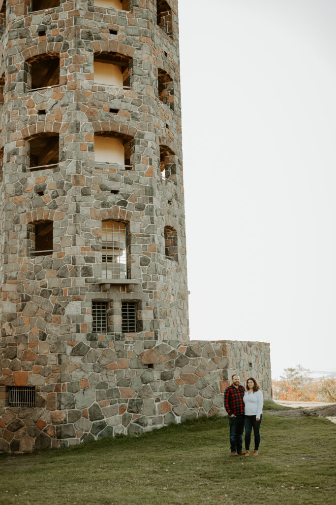 Couple stands near Enger Tower in Duluth Minnesota during engagement photo session