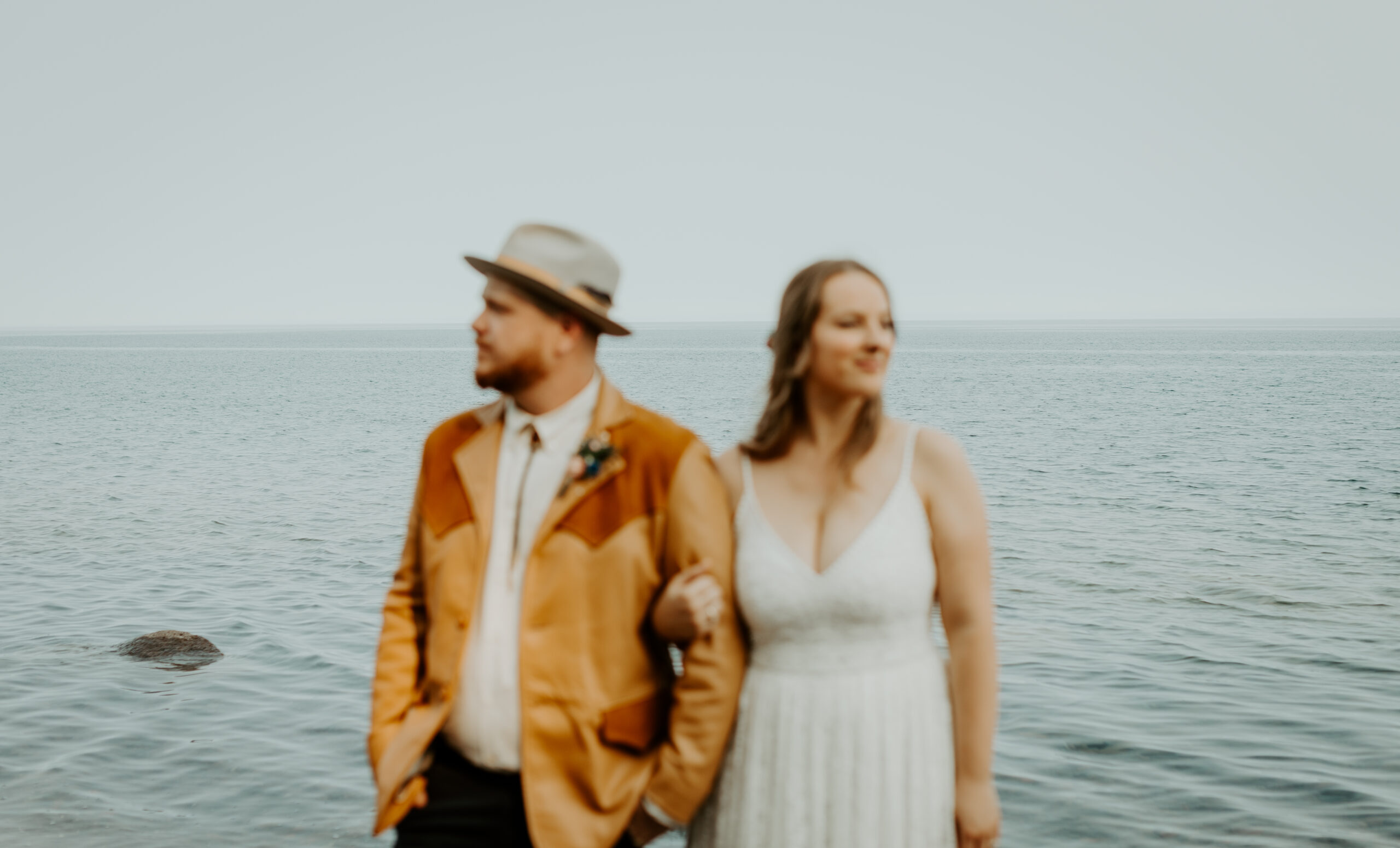 Bride and Groom stand on the shore of Lake Superior after their wedding ceremony in Grand Marais, Minnesota