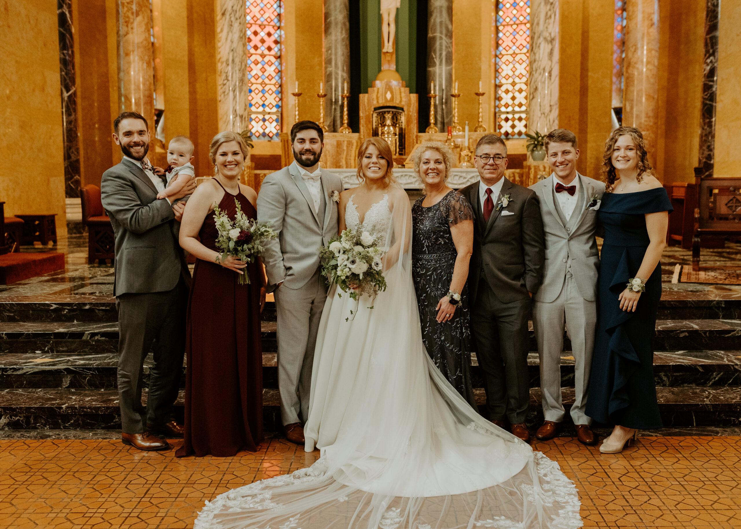 Bride and Groom stand with their family for family photos on their wedding day inside Cathedral of Our Lady of the Rosary in Duluth, Minnesota