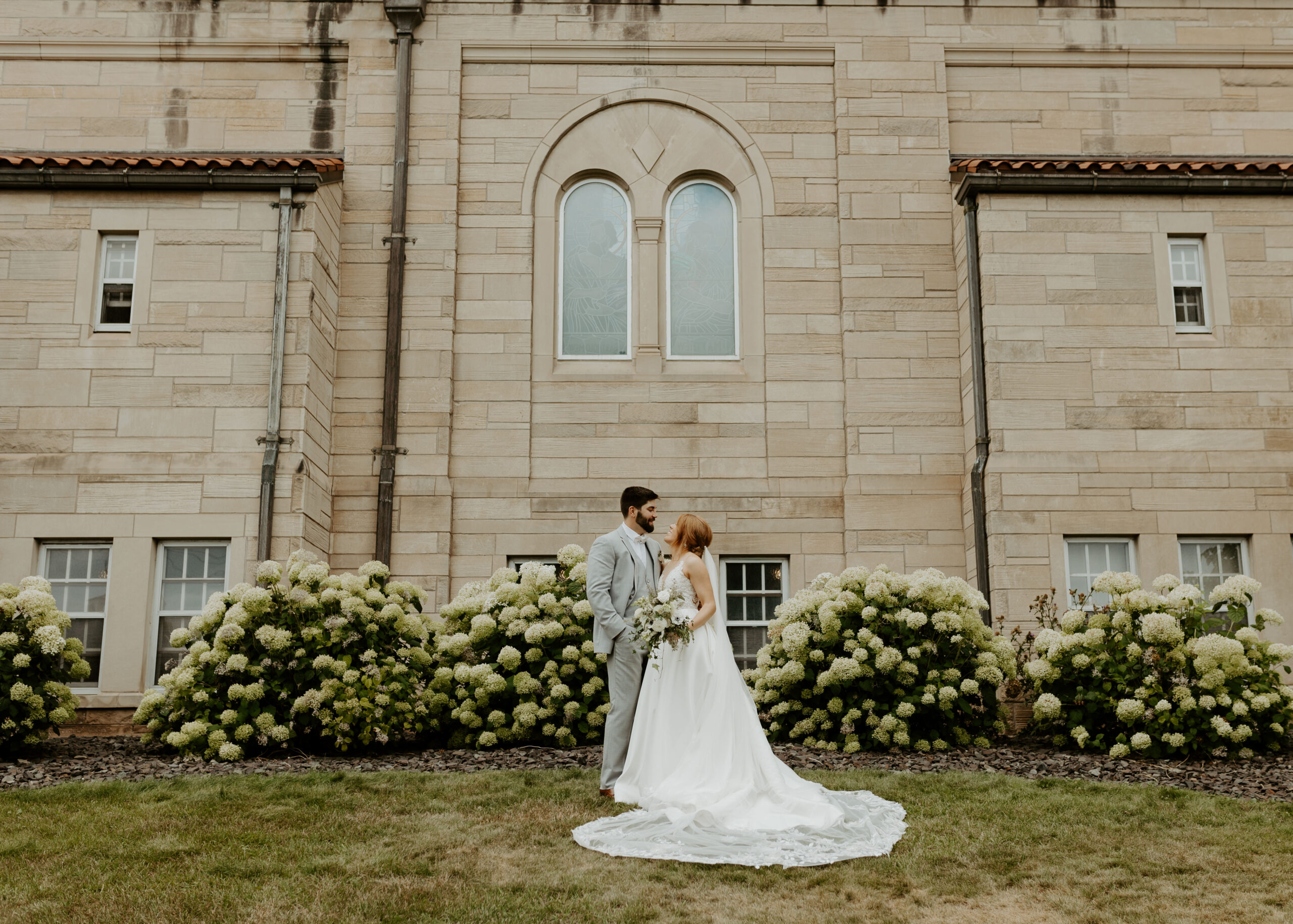 Bride and Groom stand outside of Cathedral of Our Lady of the Rosary in Duluth, Minnesota after their wedding ceremony