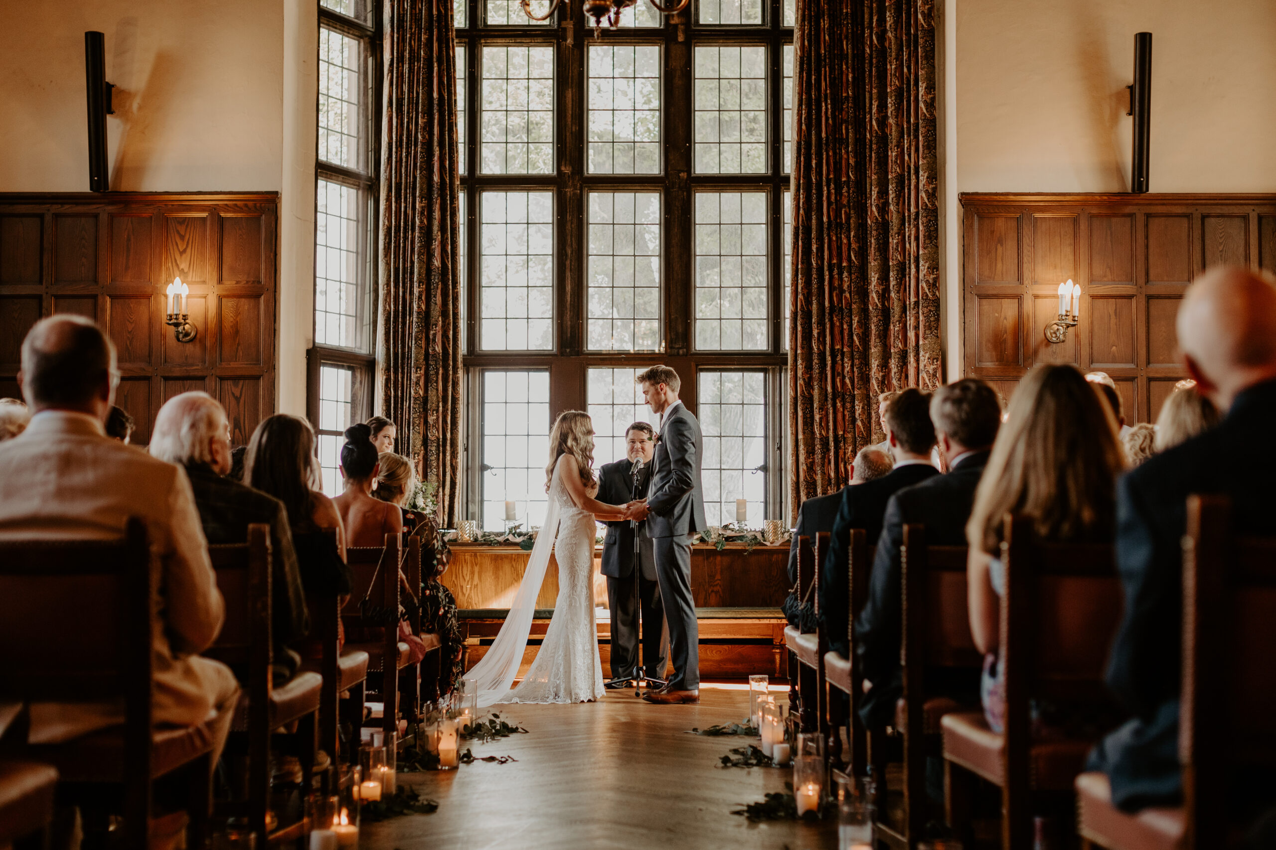 Bride and Groom stand in the Great Room at the Kitchi Gammi Club in Duluth Minnesota during their wedding ceremony