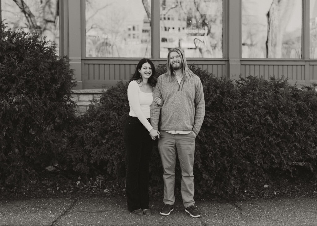 couple embraces during engagement photo session at St. Anthony Main in Minneapolis, Minnesota