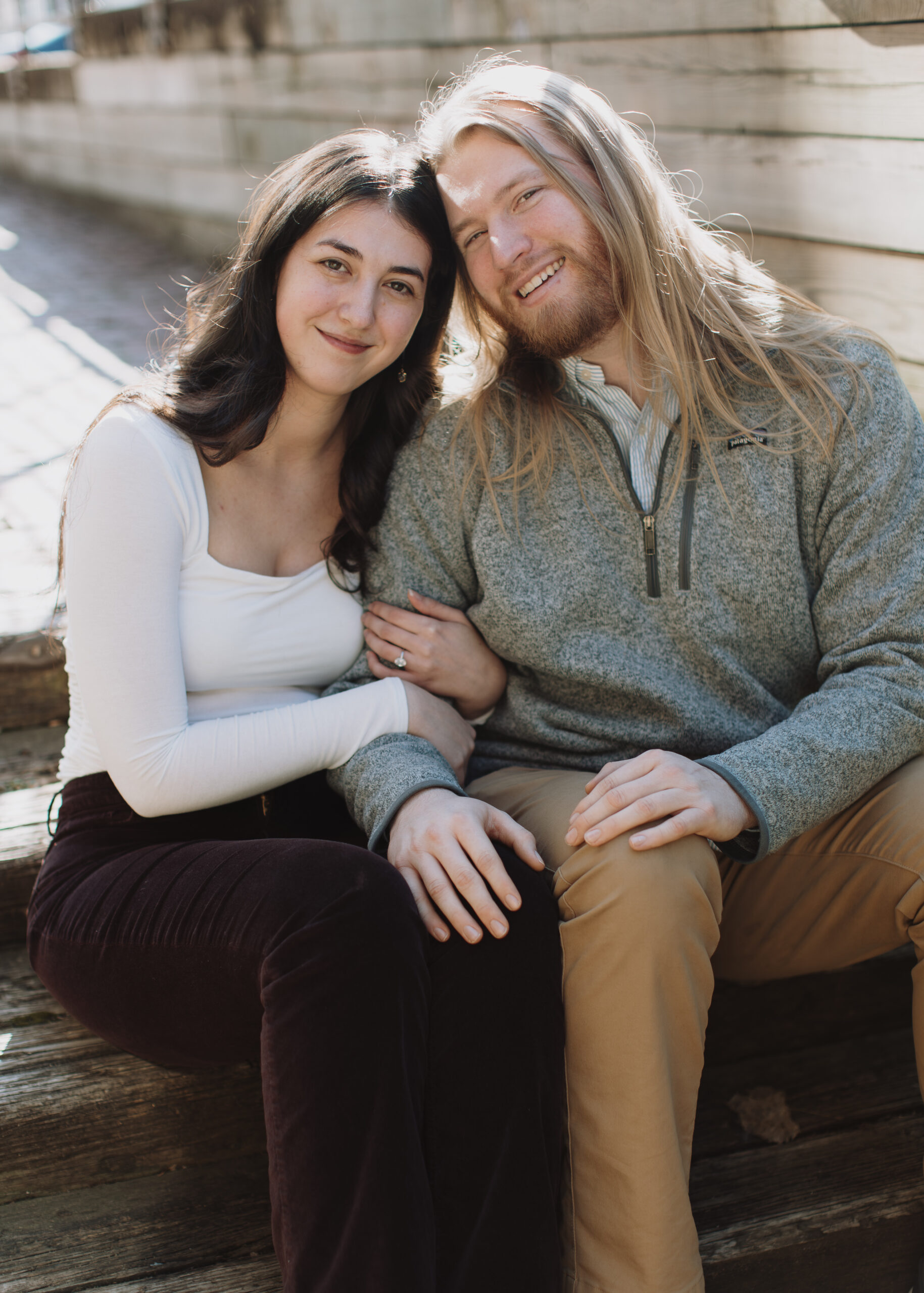 couple embraces during engagement photo session at St. Anthony Main in Minneapolis, Minnesota